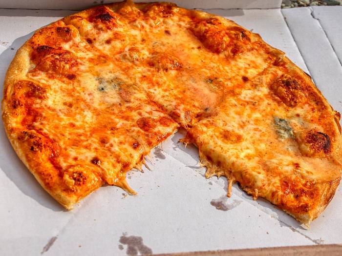Eine Pizza liegt in einem Karton vom Lieferdienst.