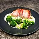 Putenroulade mit Schinken umwickelt, knusprig gebräunt. Im Vordergrund herrlich grüner Brokkoli.