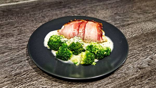 Putenroulade mit Schinken umwickelt, knusprig gebräunt. Im Vordergrund herrlich grüner Brokkoli.