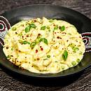Cremiges Hähnchen Curry mit Blumenkohl, garniert mit frischen Frühlingszwiebelröllchen