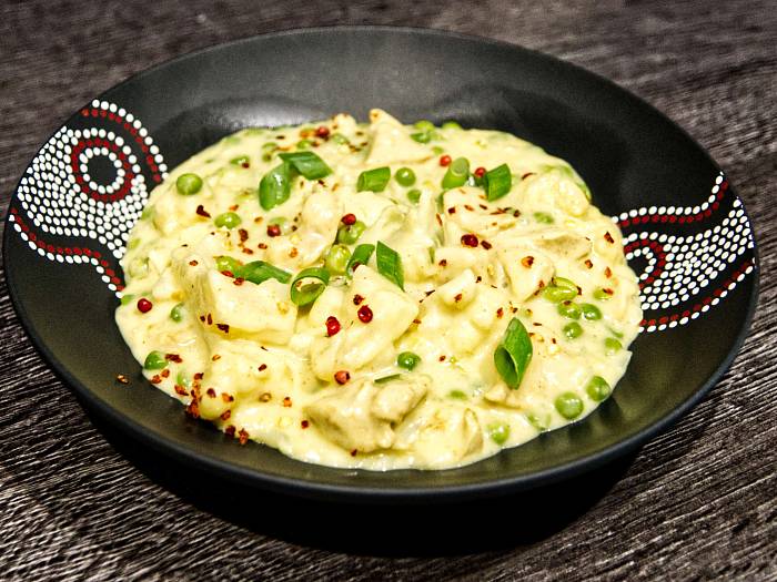 Cremiges Hähnchen Curry mit Blumenkohl, garniert mit frischen Frühlingszwiebelröllchen