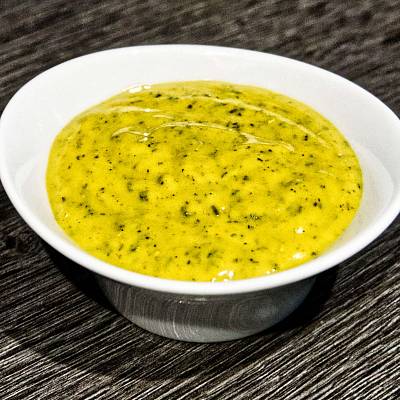 Leuchtend gelbe Honig-Senf-Sauce mit Rosmarin und Thymian