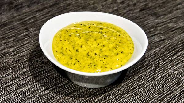 Leuchtend gelbe Honig-Senf-Sauce mit Rosmarin und Thymian