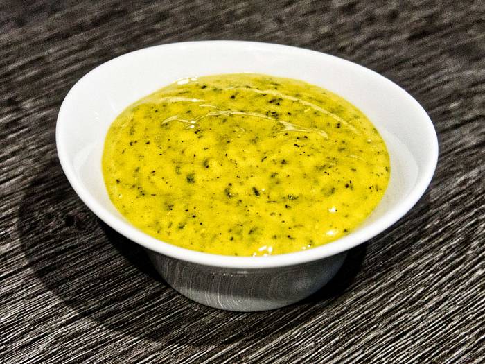 Leuchtend gelbe Honig-Senf-Sauce mit Rosmarin und Thymian