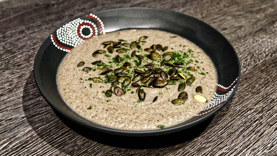 Suppe aus Champignons, püriert; garniert mit Kürbiskernen und Petersilie