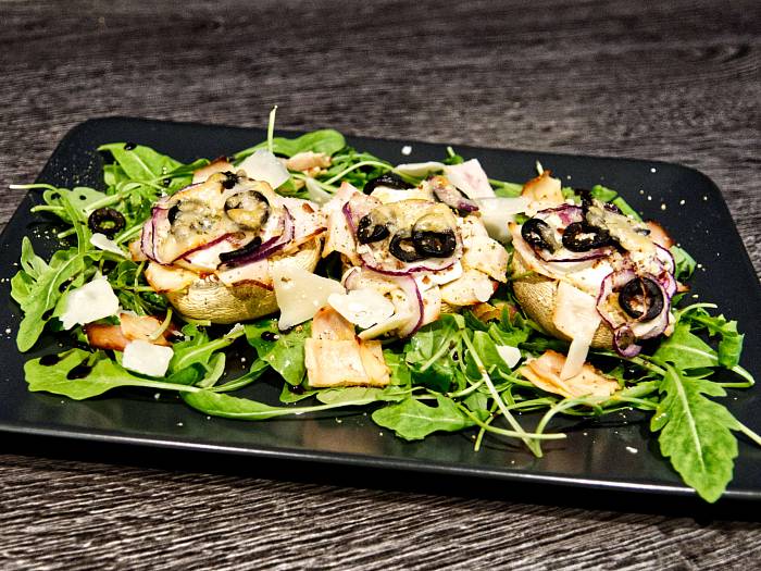 Gefüllte braune Champignons auf Salatbett