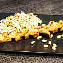 Spieß mit Lachs und Garnelen neben einem Salat aus Kohlrabi