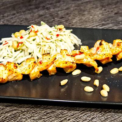Spieß mit Lachs und Garnelen neben einem Salat aus Kohlrabi