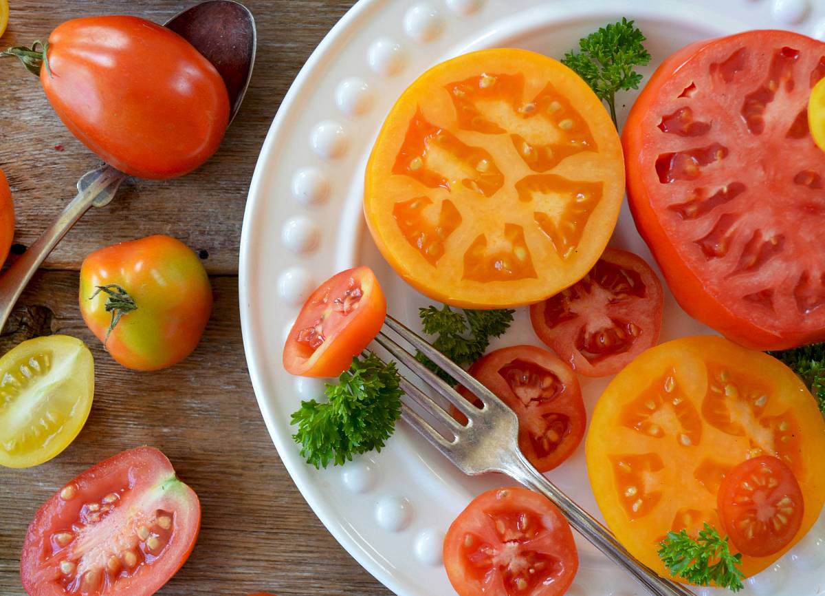 Aufgeschnittene Tomaten (verschiedene Sorten) von oben fotografiert.