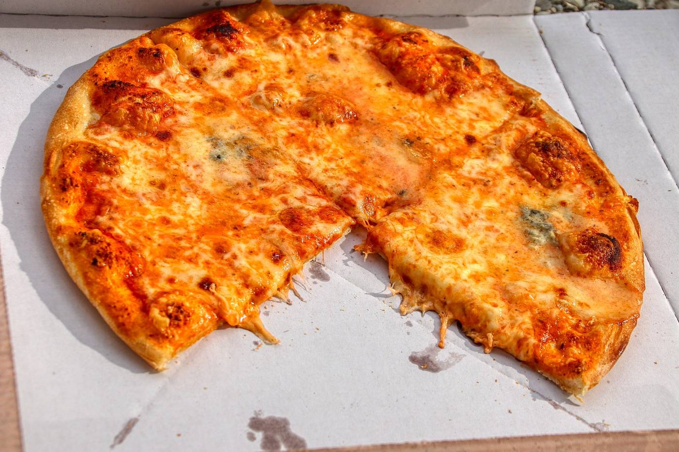 Eine Pizza liegt in einem Karton vom Lieferdienst.